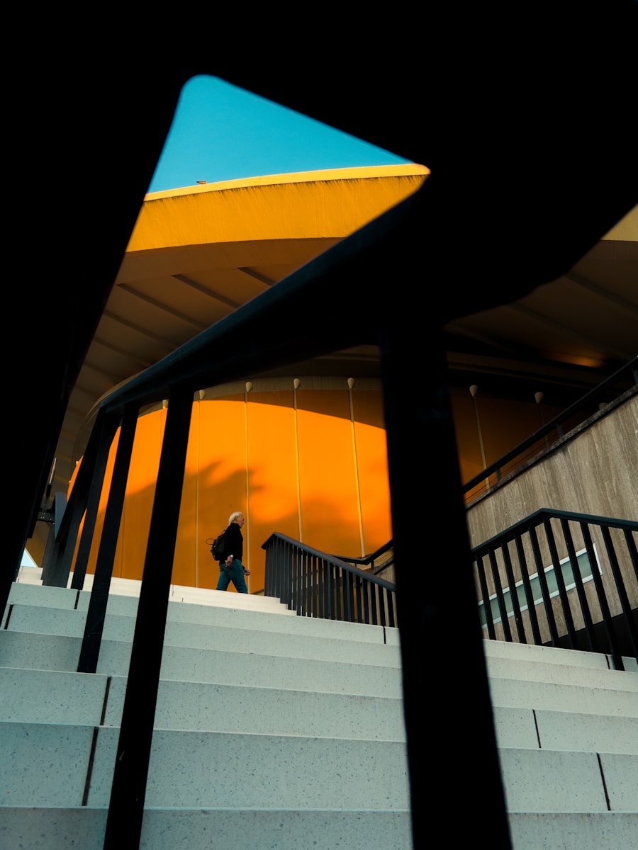 Man walks up stairs towards orange building